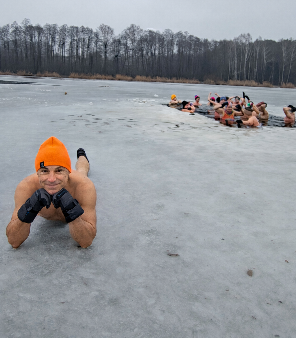 Mężczyzna leży na brzuchu na zamarzniętym jeziorze